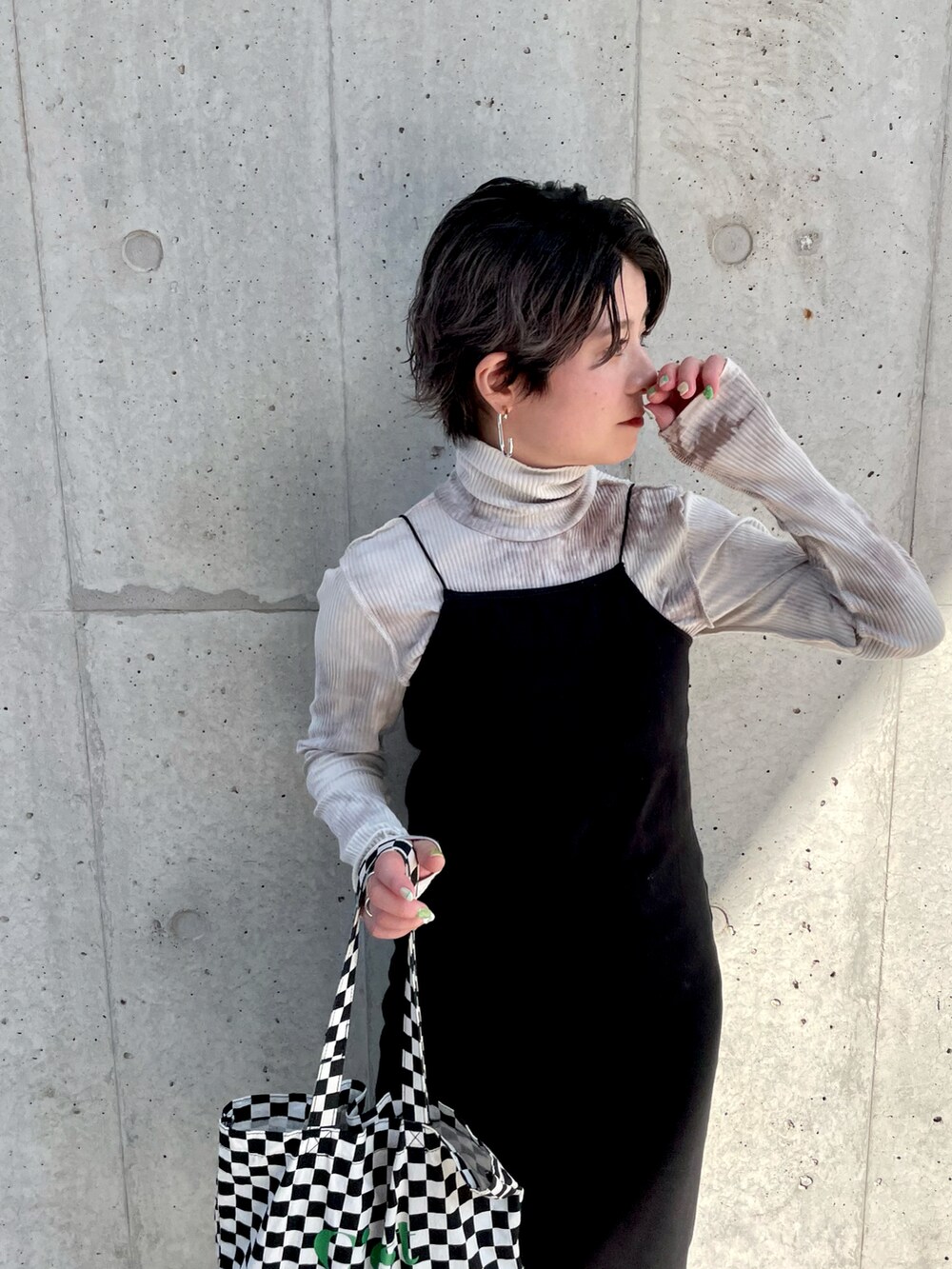 ブラック系のトートバッグ、ブラック系のワンピース、ベージュ系のTシャツ/カットソーを着用したレディースの春コーディネートの3枚目の写真