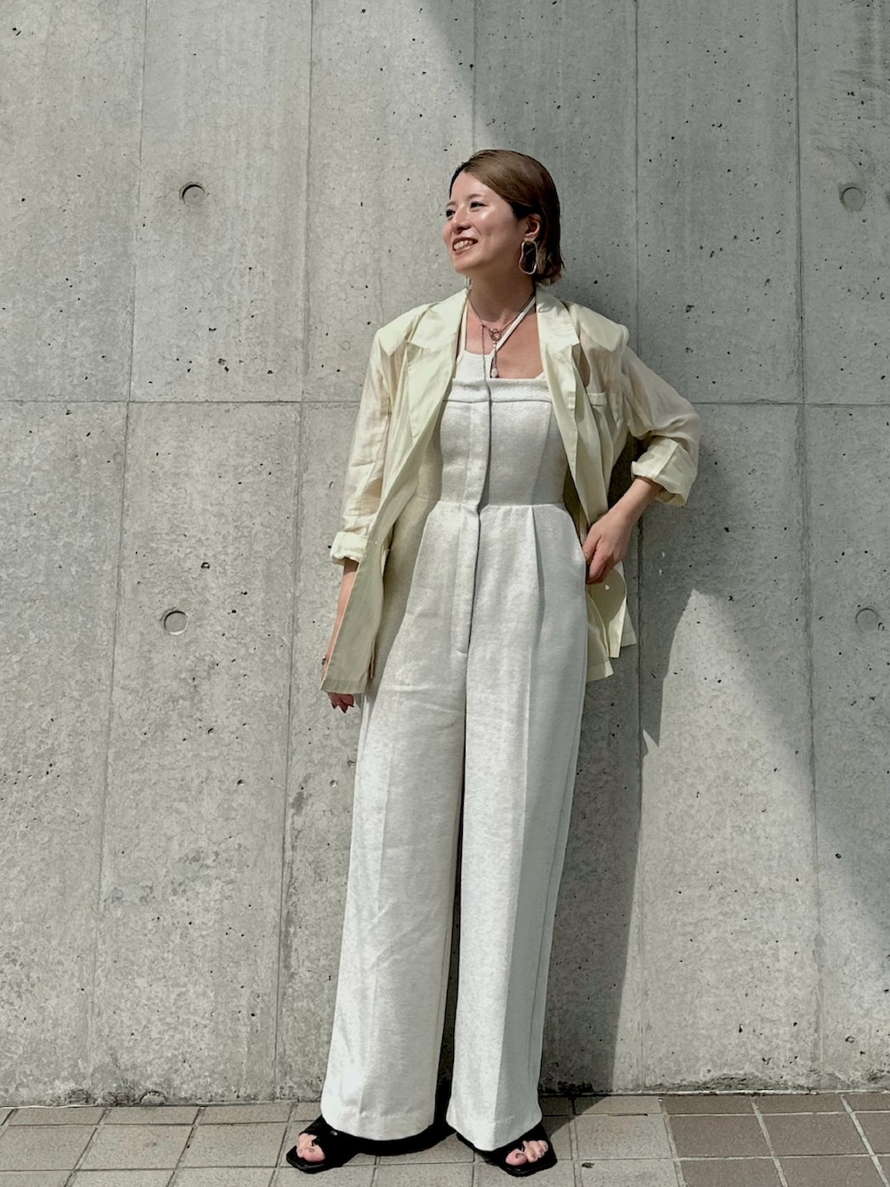 ホワイト系のサロペット/オーバーオール、イエロー系のテーラードジャケット、ホワイト系のキャミソールを着用したレディースの夏コーディネートの2枚目の写真