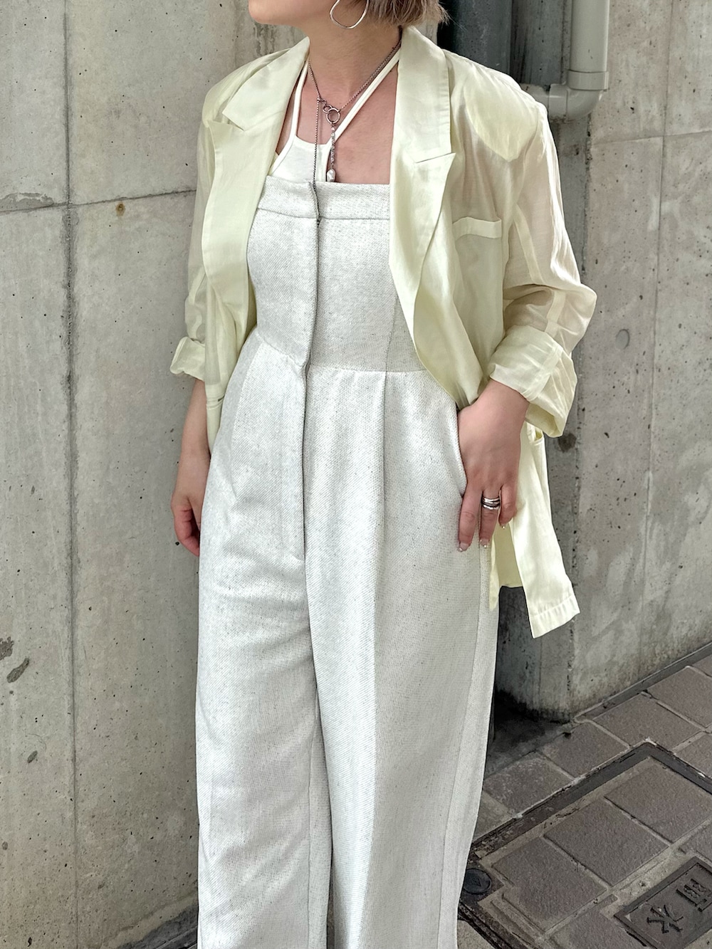 ホワイト系のサロペット/オーバーオール、イエロー系のテーラードジャケット、ホワイト系のキャミソールを着用したレディースの夏コーディネートの3枚目の写真