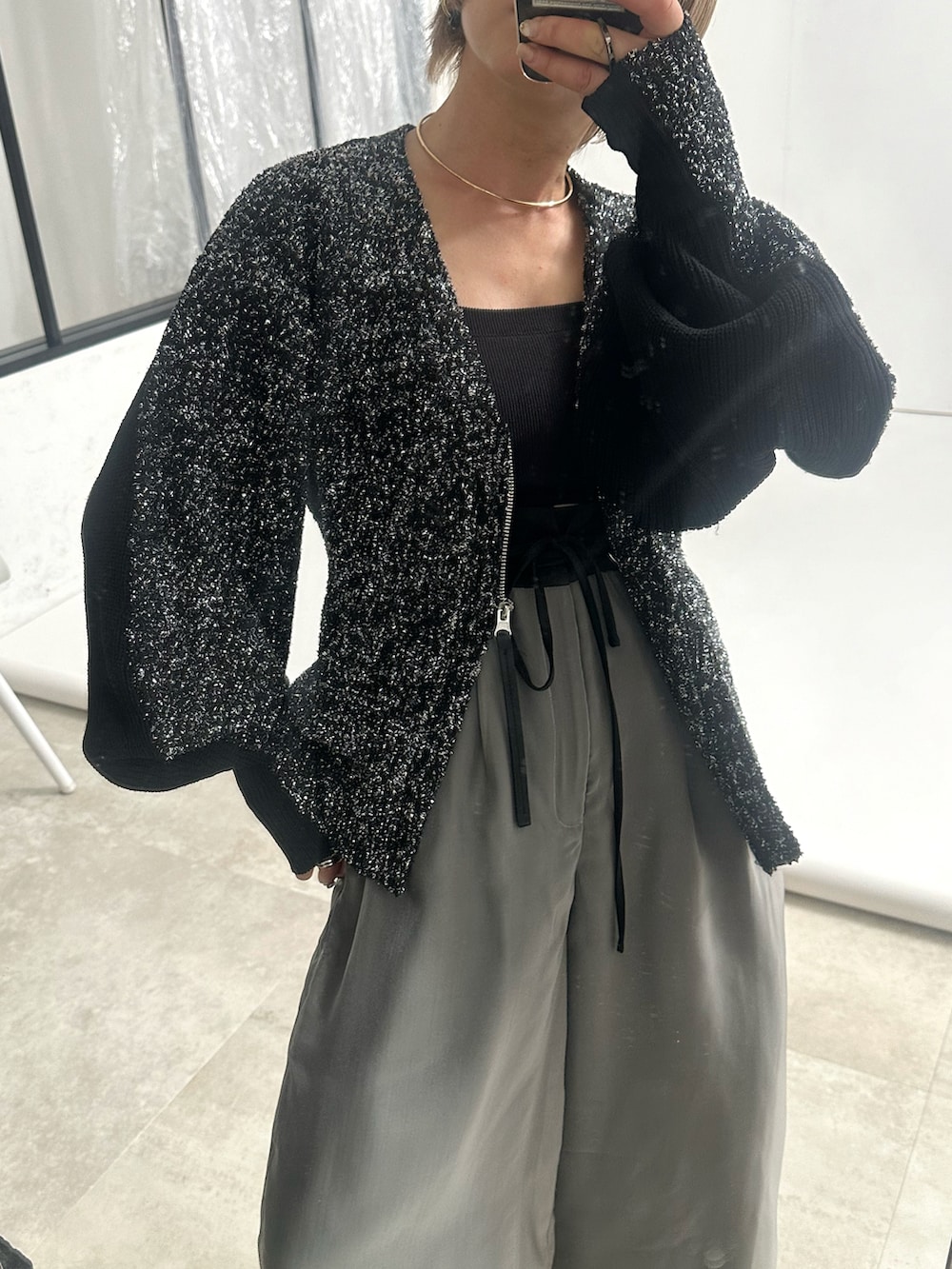 グレー系のその他パンツ、シルバー系のカーディガン/ボレロ、シルバー系のブーツを着用したレディースの秋コーディネートの2枚目の写真