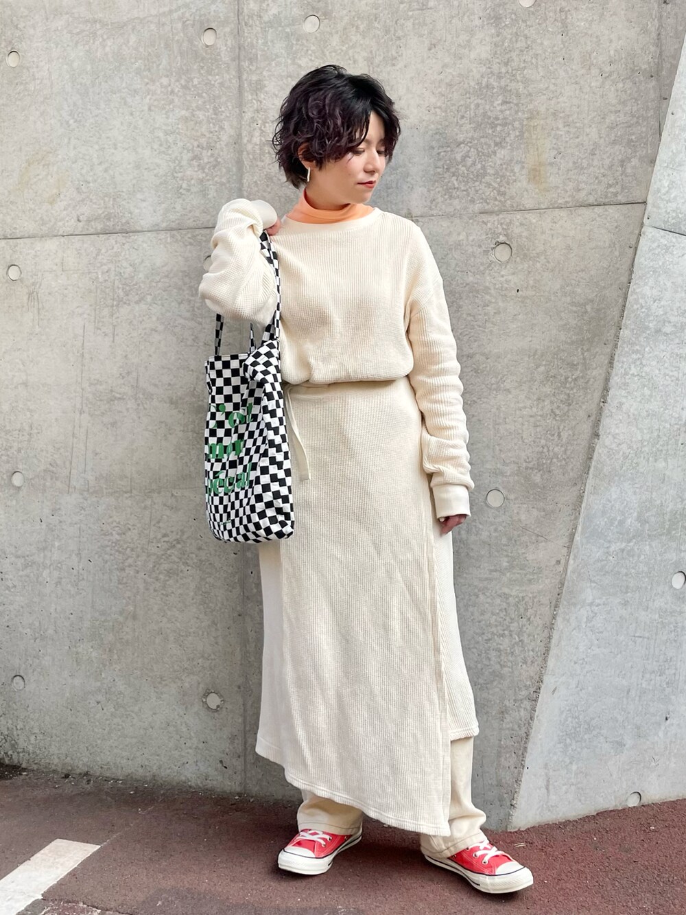 ピンク系のスニーカー、ホワイト系のデニムパンツ、ブラック系のトートバッグを着用したレディースの冬コーディネートの2枚目の写真