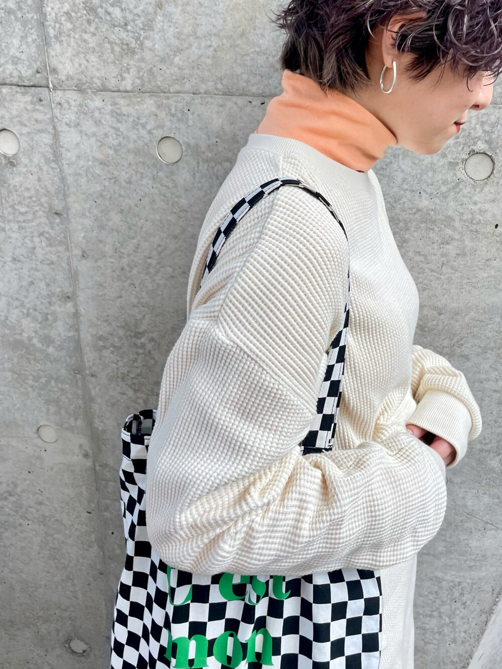 ピンク系のスニーカー、ホワイト系のデニムパンツ、ブラック系のトートバッグを着用したレディースの冬コーディネートの4枚目の写真