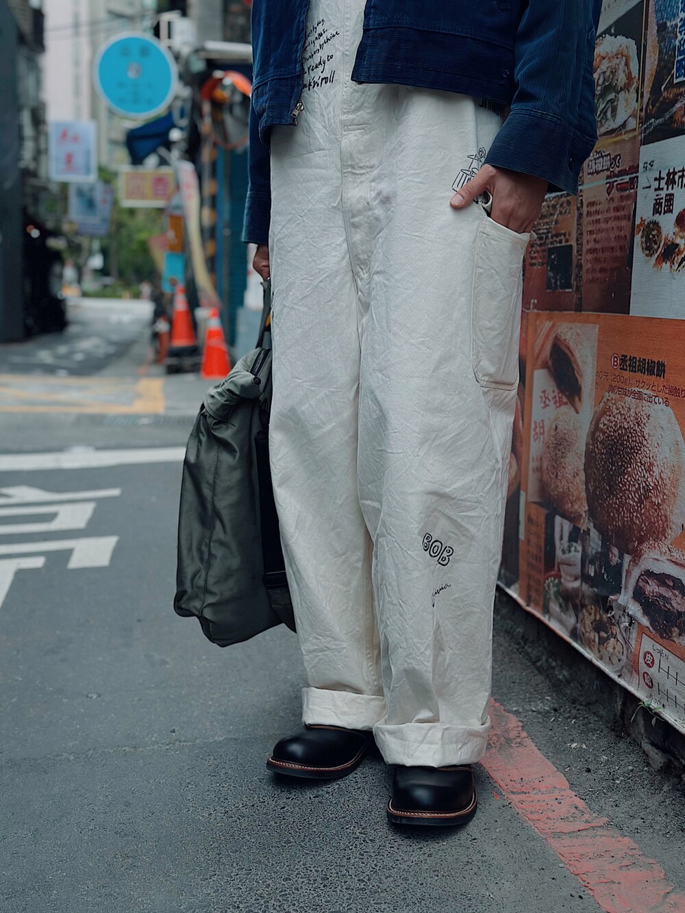 グリーン系のトートバッグ、ブラック系のハンチング/ベレー帽を着用したメンズの冬コーディネートの3枚目の写真