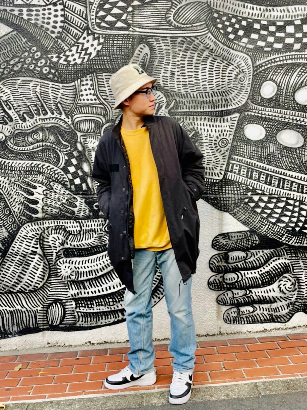 ブラック系のモッズコート、その他のデニムパンツ、ホワイト系のスニーカーを着用したメンズの冬コーディネートの2枚目の写真