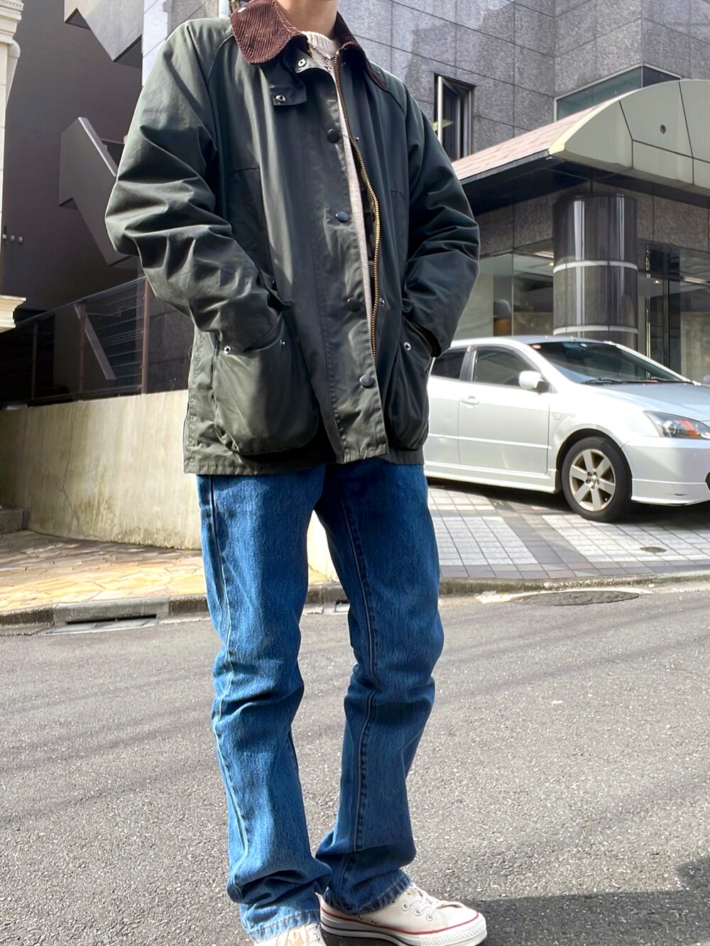 グリーン系のブルゾン、ブルー系のデニムパンツを着用したメンズの春コーディネートの2枚目の写真