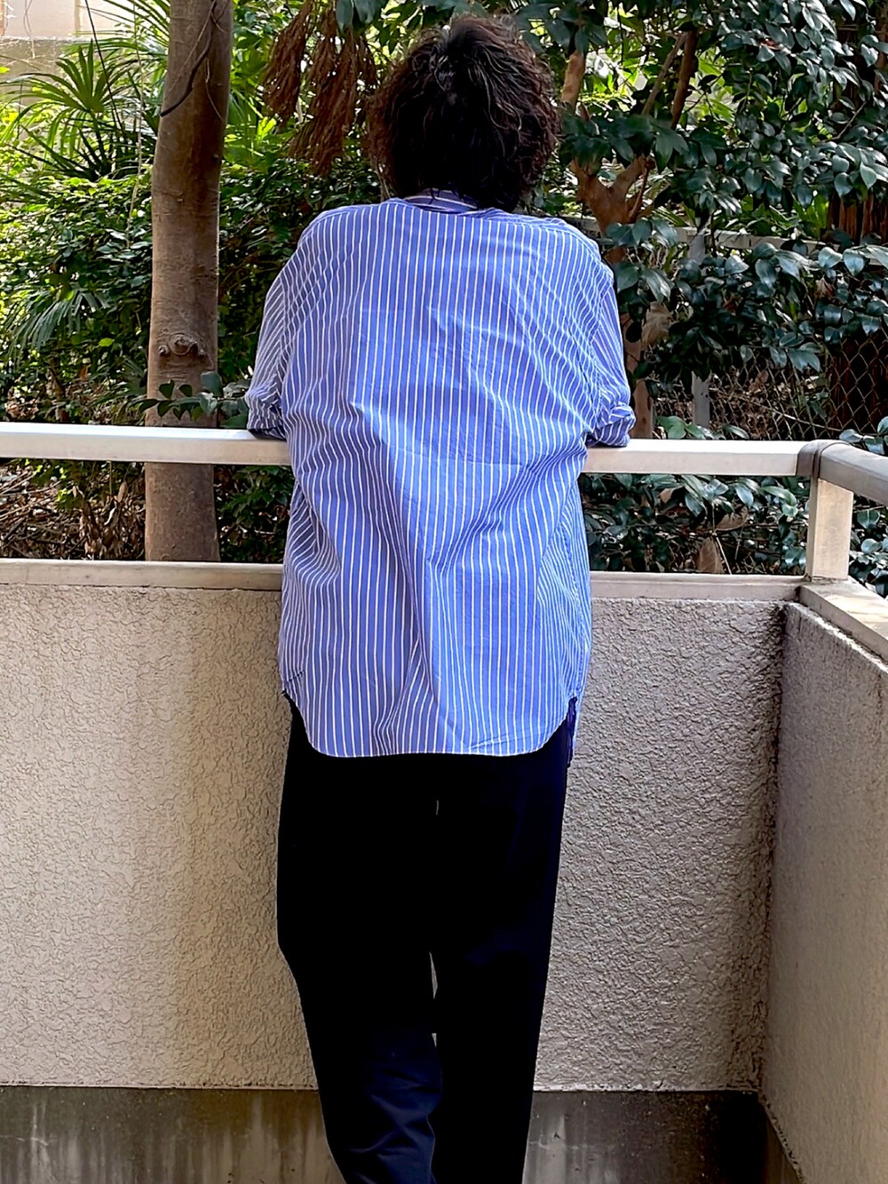 ブルー系のシャツ/ブラウス、グレー系のスニーカー、ブラック系のスラックスを着用したメンズの春コーディネートの2枚目の写真