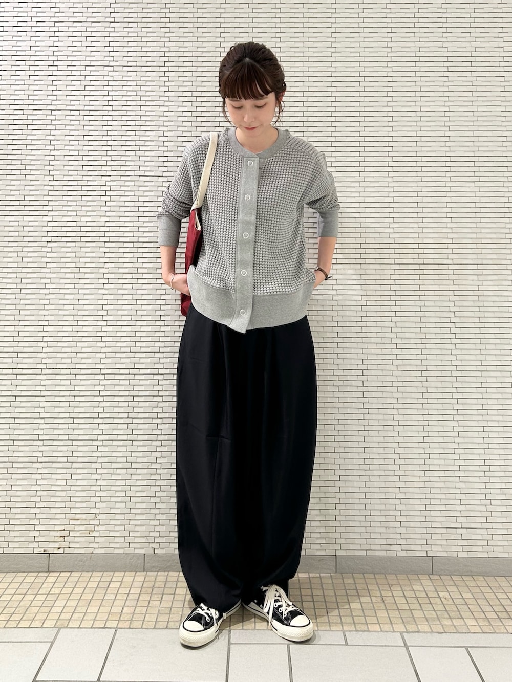 ブルー系のその他パンツ、グレー系のカーディガン/ボレロ、レッド系のトートバッグを着用したレディースの秋コーディネートの3枚目の写真