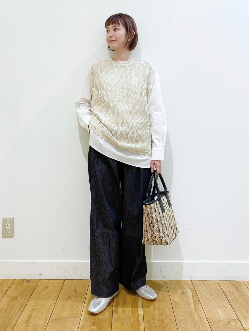 ベージュ系のベスト、ホワイト系のシャツ/ブラウス、シルバー系のパンプスを着用したレディースの春コーディネートの2枚目の写真