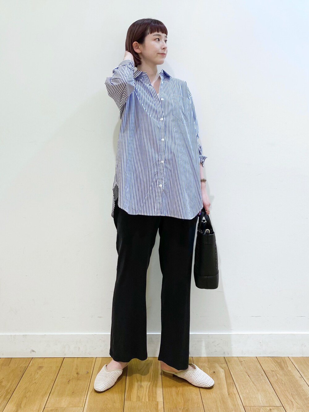 ブルー系のシャツ/ブラウス、ブラック系のその他パンツ、ホワイト系のサンダルを着用したレディースの春コーディネートの2枚目の写真