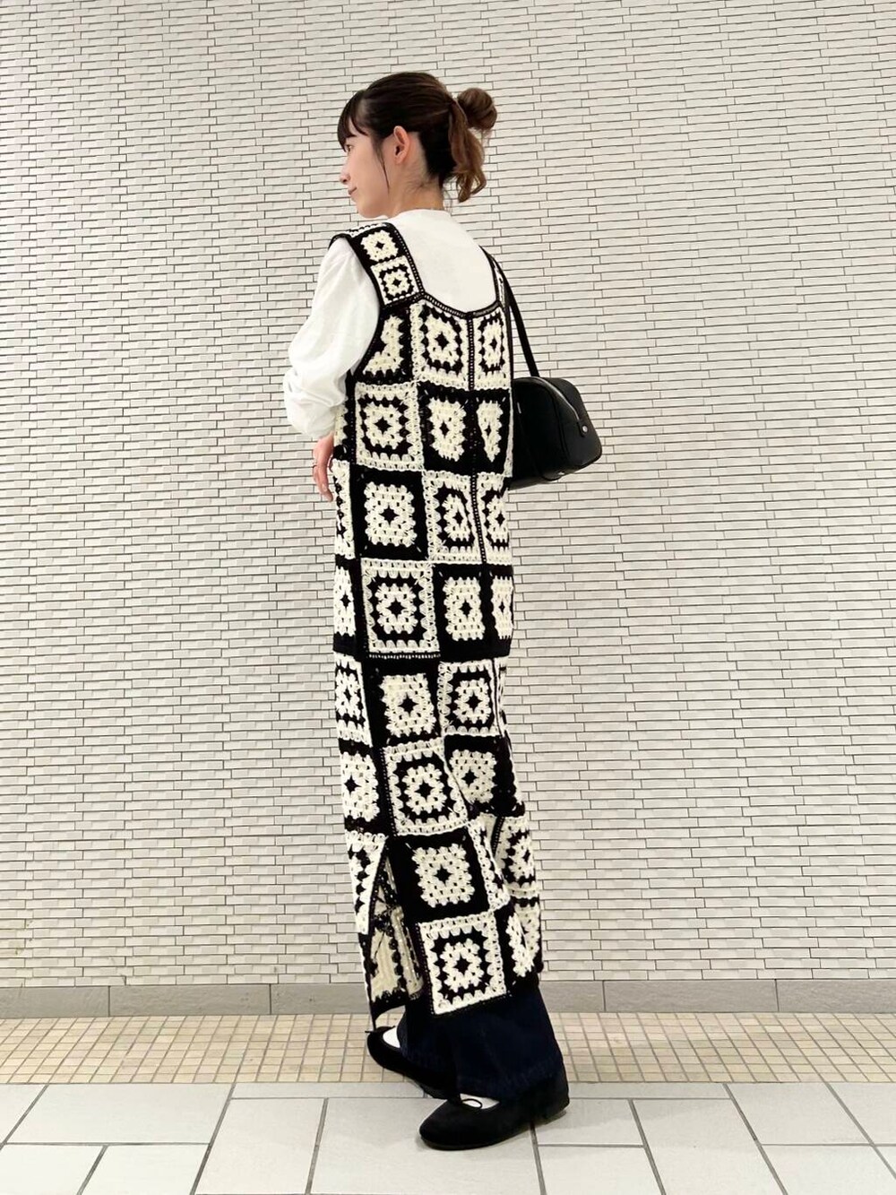 ブルー系のデニムパンツ、ブラック系のバレエシューズ、ホワイト系のTシャツ/カットソーを着用したレディースの夏コーディネートの5枚目の写真