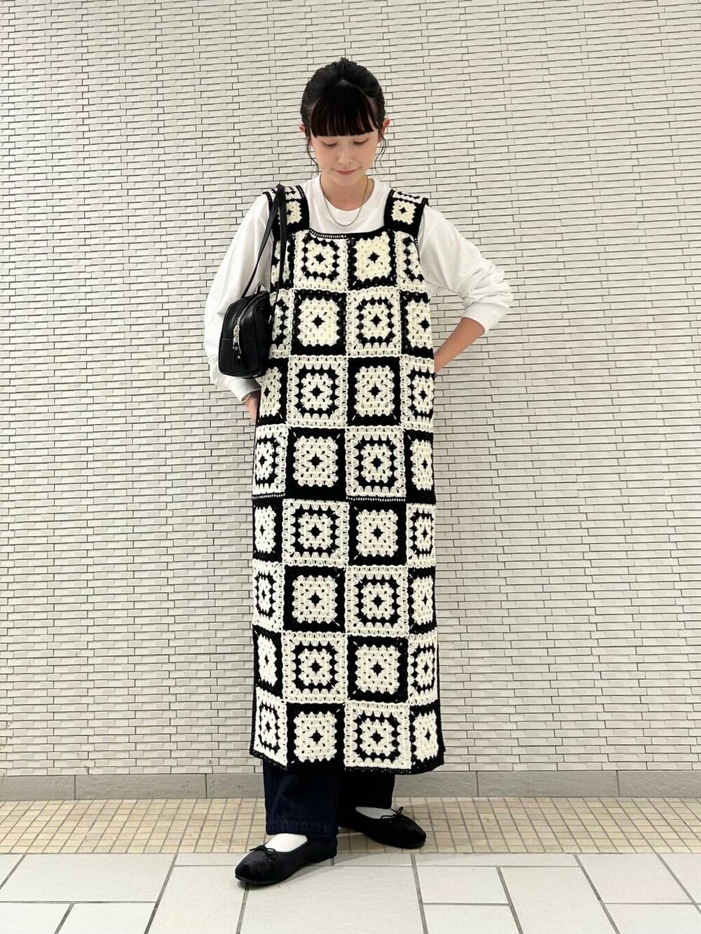 ブルー系のデニムパンツ、ブラック系のバレエシューズ、ホワイト系のTシャツ/カットソーを着用したレディースの夏コーディネートの2枚目の写真