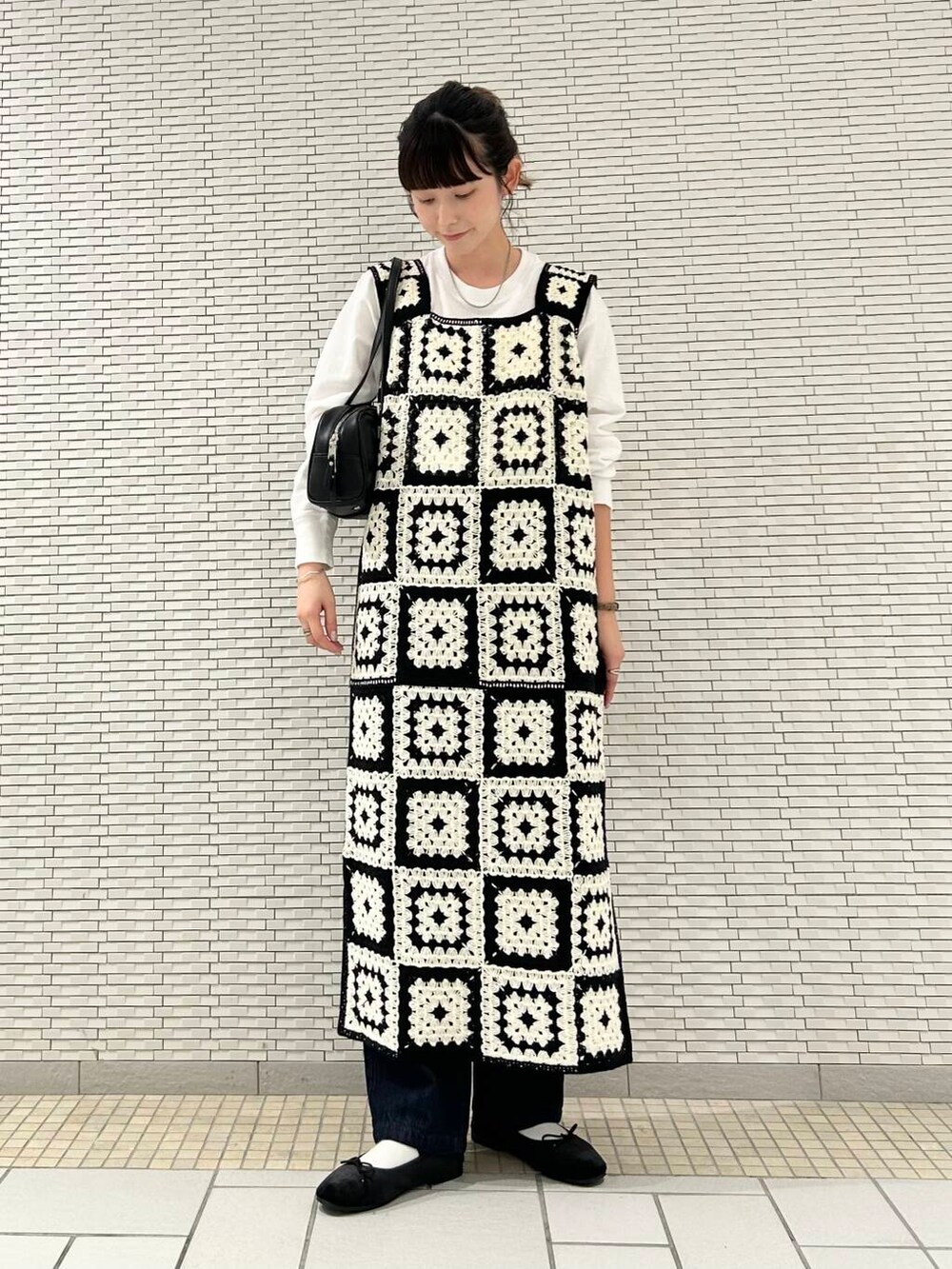 ブルー系のデニムパンツ、ブラック系のバレエシューズ、ホワイト系のTシャツ/カットソーを着用したレディースの夏コーディネートの3枚目の写真