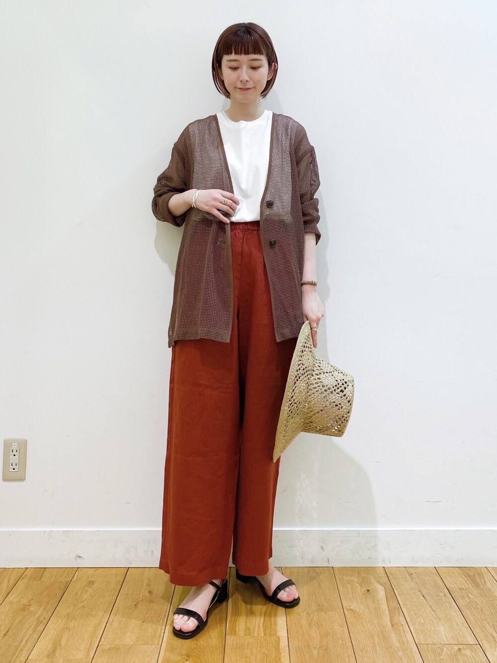 ホワイト系のTシャツ/カットソー、ブラウン系のカーディガン/ボレロ、ブラック系のサンダルを着用したレディースの春コーディネートの2枚目の写真
