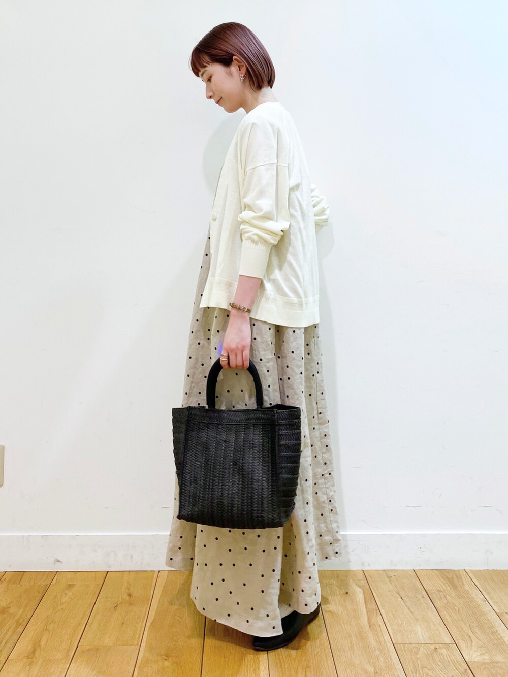 ホワイト系のカーディガン/ボレロ、ベージュ系のワンピース、ブラック系のパンプスを着用したレディースの春コーディネートの3枚目の写真