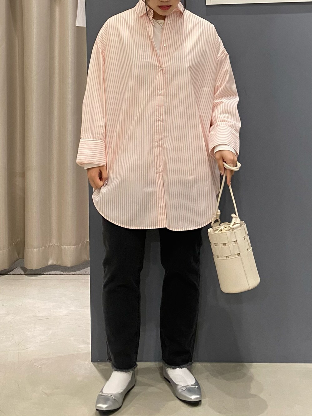 オレンジ系のシャツ/ブラウス、グレー系のデニムパンツ、ホワイト系のショルダーバッグを着用したレディースの春コーディネートの3枚目の写真