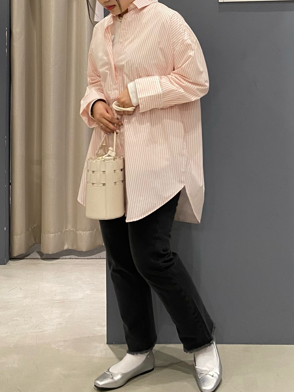 オレンジ系のシャツ/ブラウス、グレー系のデニムパンツ、ホワイト系のショルダーバッグを着用したレディースの春コーディネートの2枚目の写真