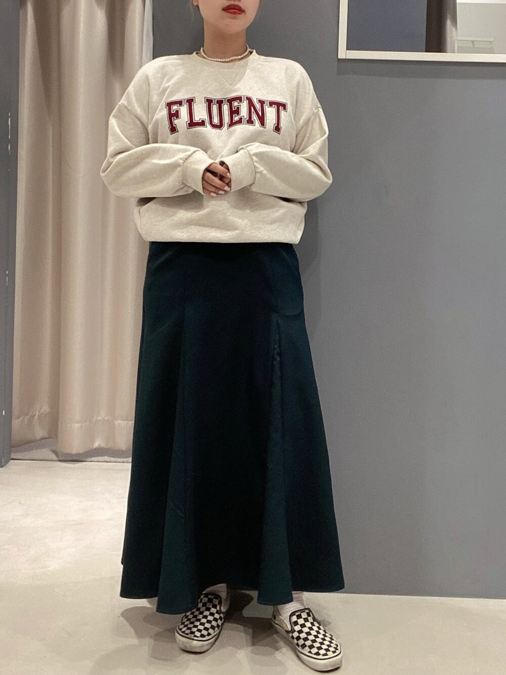 ホワイト系のスウェット、グリーン系のスカート、その他のスリッポンを着用したレディースの秋コーディネートの2枚目の写真