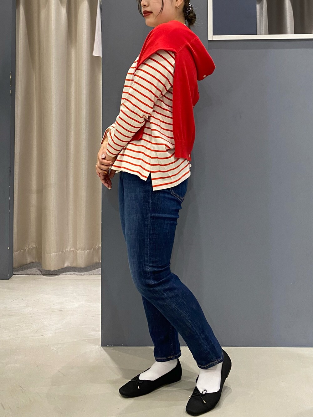 レッド系のTシャツ/カットソー、レッド系のカーディガン/ボレロ、ブルー系のデニムパンツを着用したレディースの春コーディネートの3枚目の写真