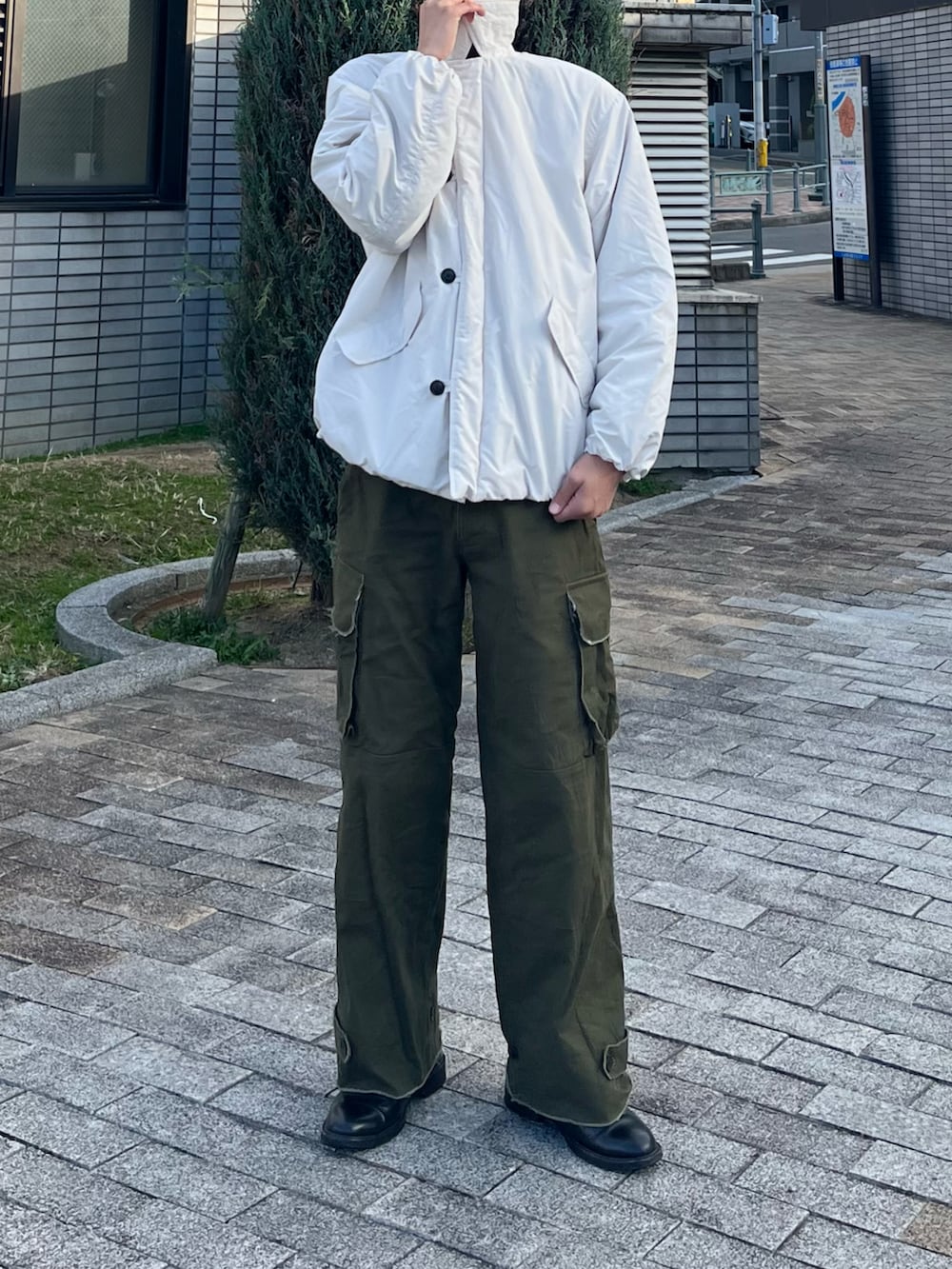 ホワイト系のダウンジャケット/コート、グリーン系のカーゴパンツ、ブラック系のブーツを着用したメンズの冬コーディネートの2枚目の写真
