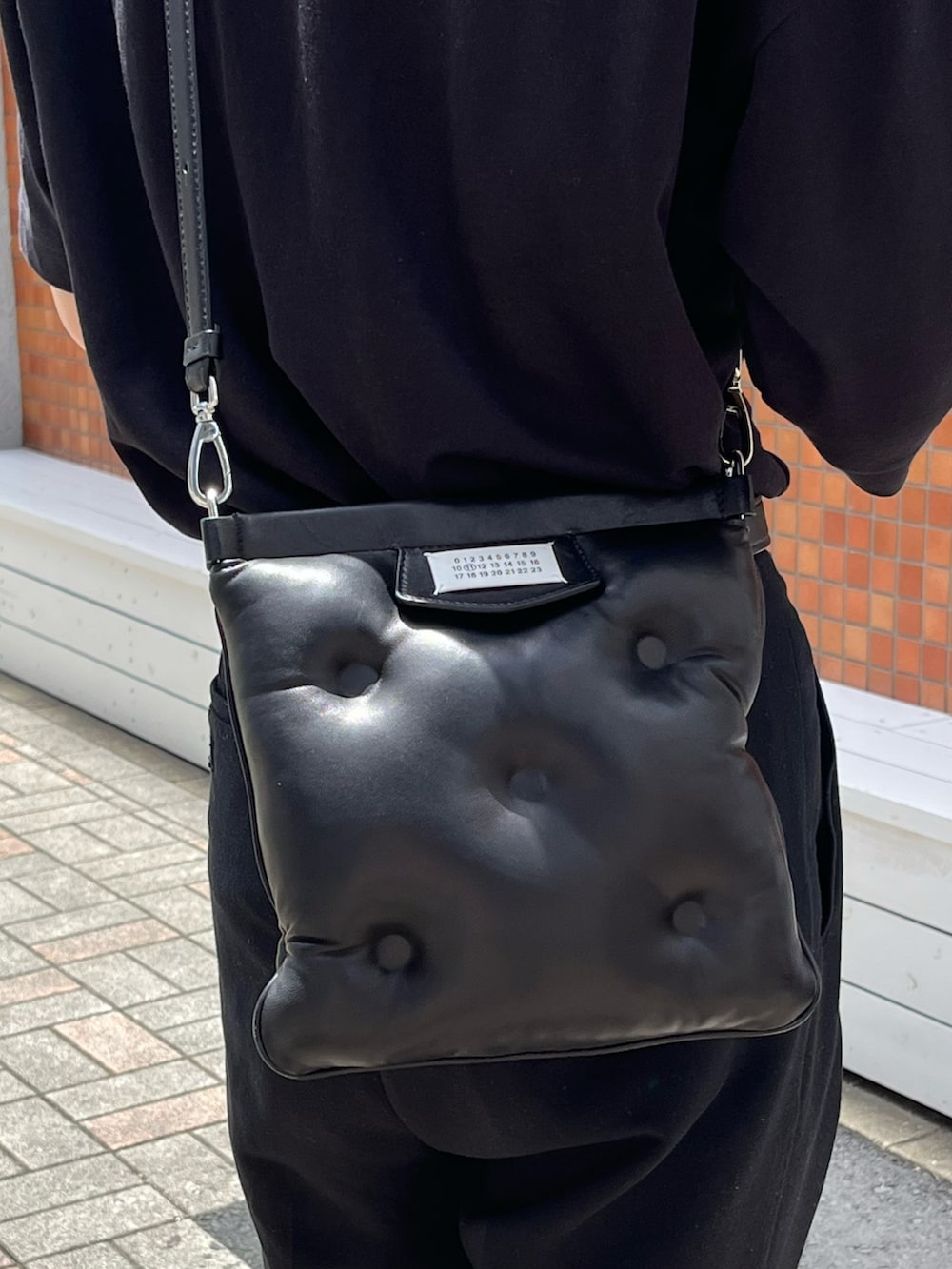 ブラック系のTシャツ/カットソー、ブラック系のスラックス、ブラック系のブーツを着用したメンズの夏コーディネートの5枚目の写真