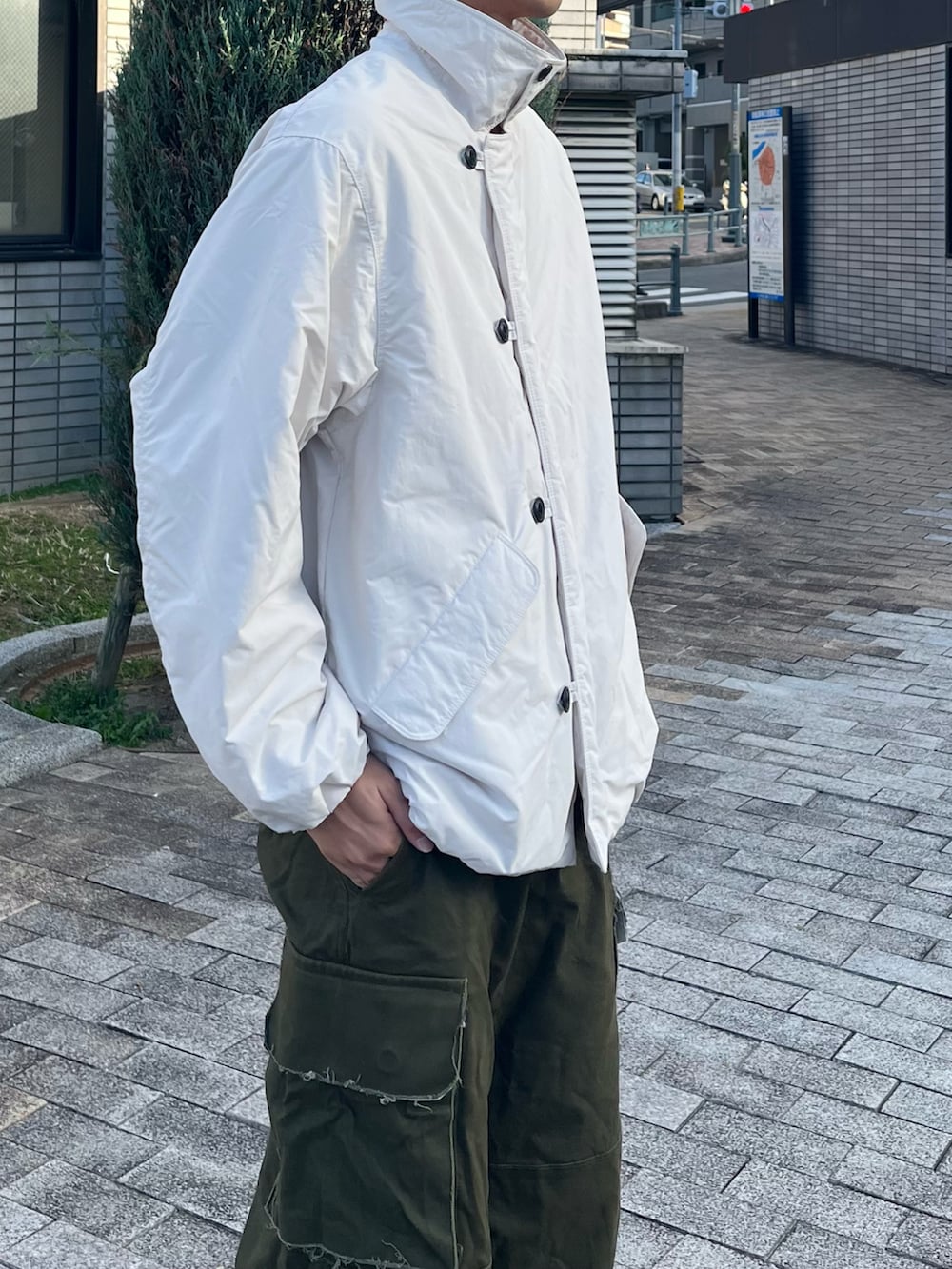 ホワイト系のダウンジャケット/コート、グリーン系のカーゴパンツ、ブラック系のブーツを着用したメンズの冬コーディネートの3枚目の写真