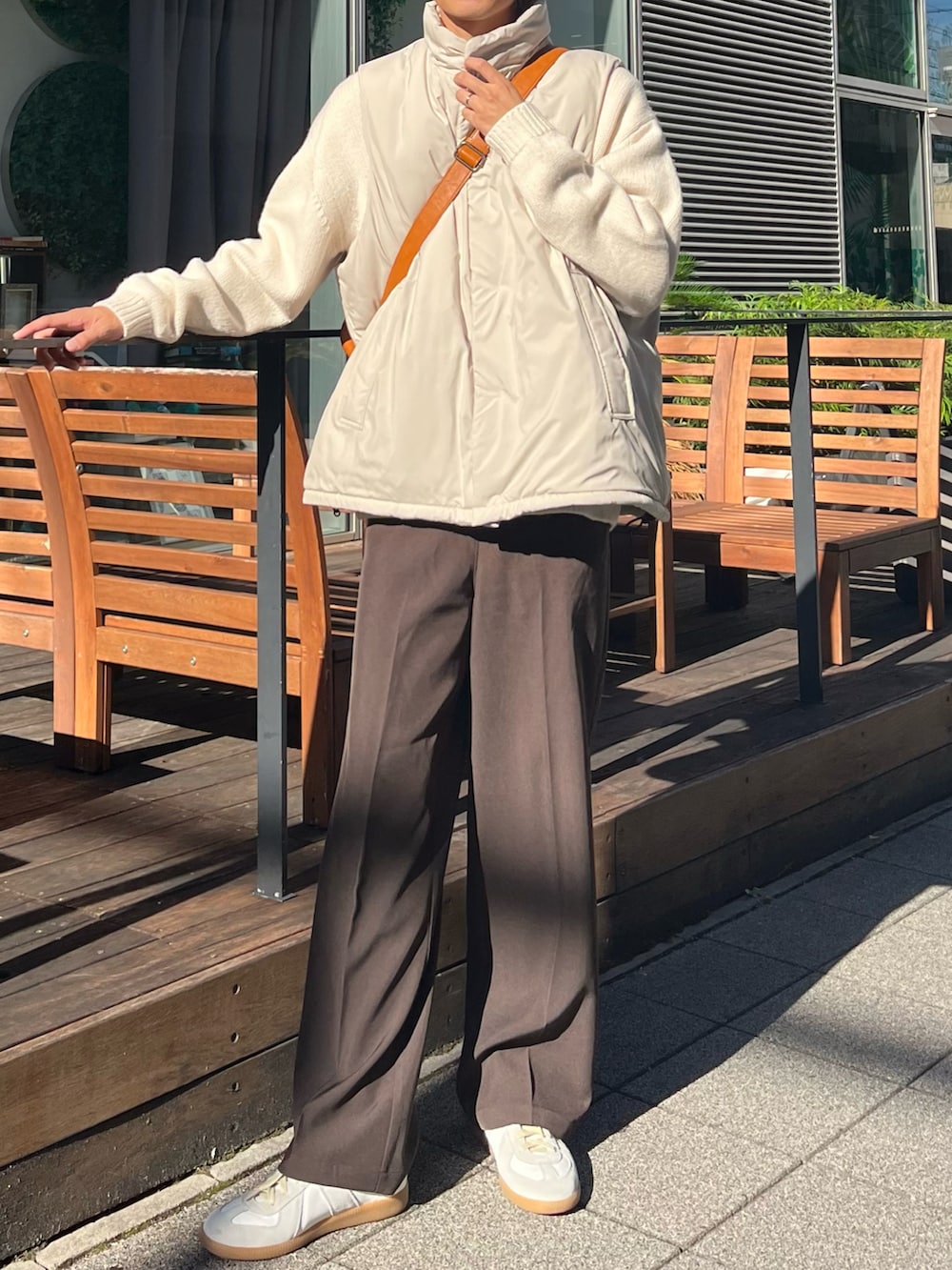 ブラウン系のボストンバッグ、ホワイト系のニット/セーター、ブラウン系のスラックスを着用したメンズの秋コーディネートの3枚目の写真