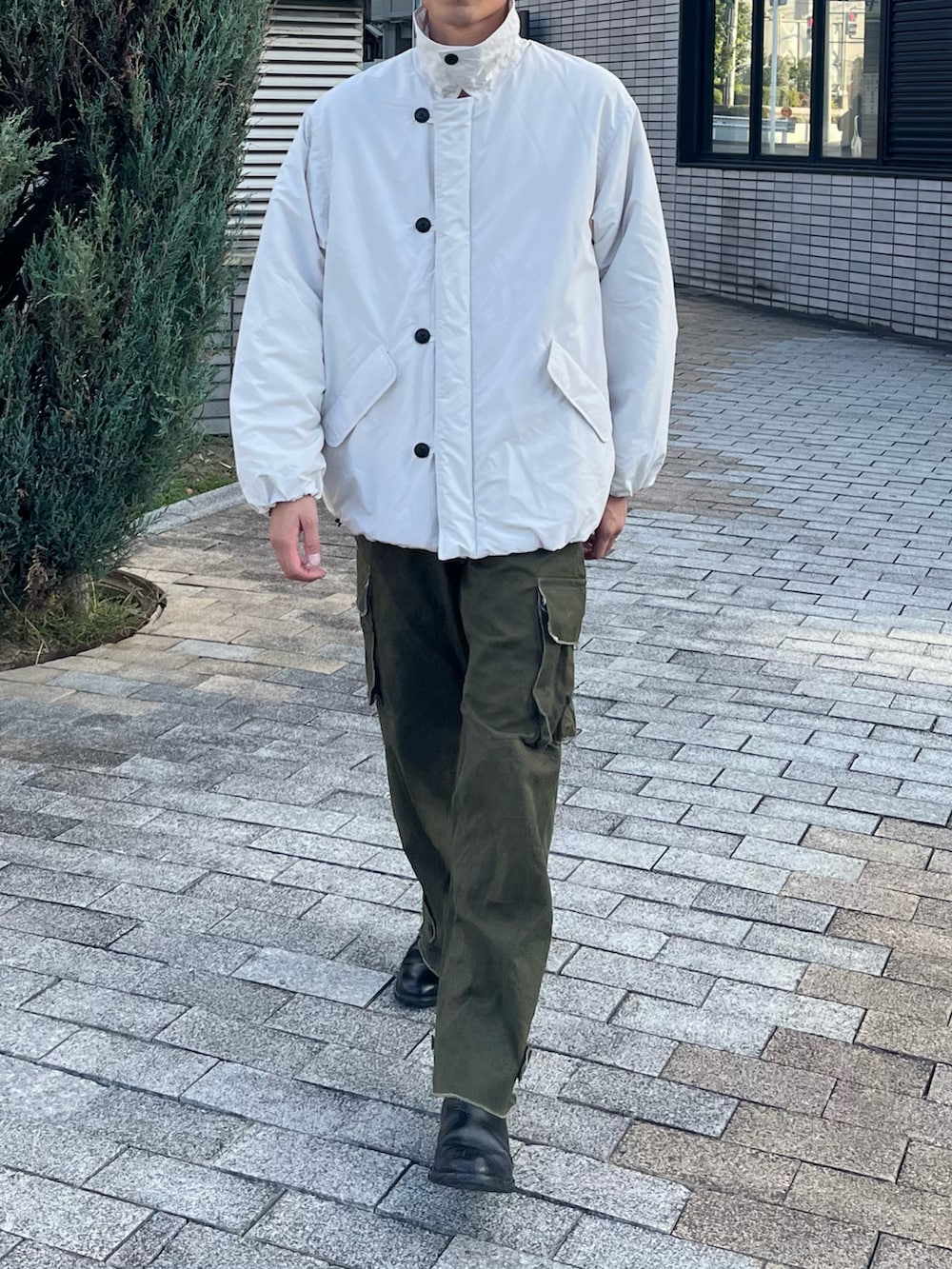 ホワイト系のダウンジャケット/コート、グリーン系のカーゴパンツ、ブラック系のブーツを着用したメンズの冬コーディネートの4枚目の写真
