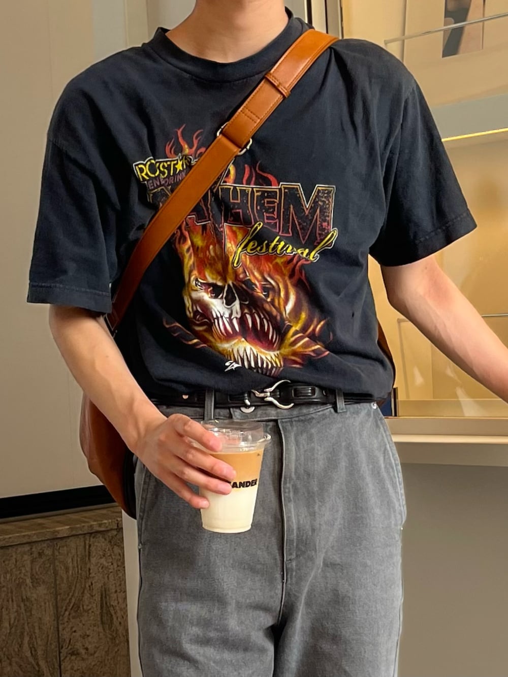 グレー系のデニムパンツ、ブラック系のブーツ、ブラウン系のボストンバッグを着用したメンズの春コーディネートの2枚目の写真