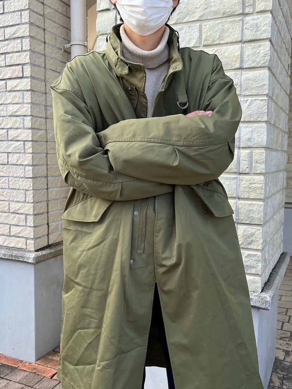 グレー系のスニーカー、グリーン系のその他アウター、ベージュ系のニット/セーターを着用したメンズの冬コーディネートの3枚目の写真