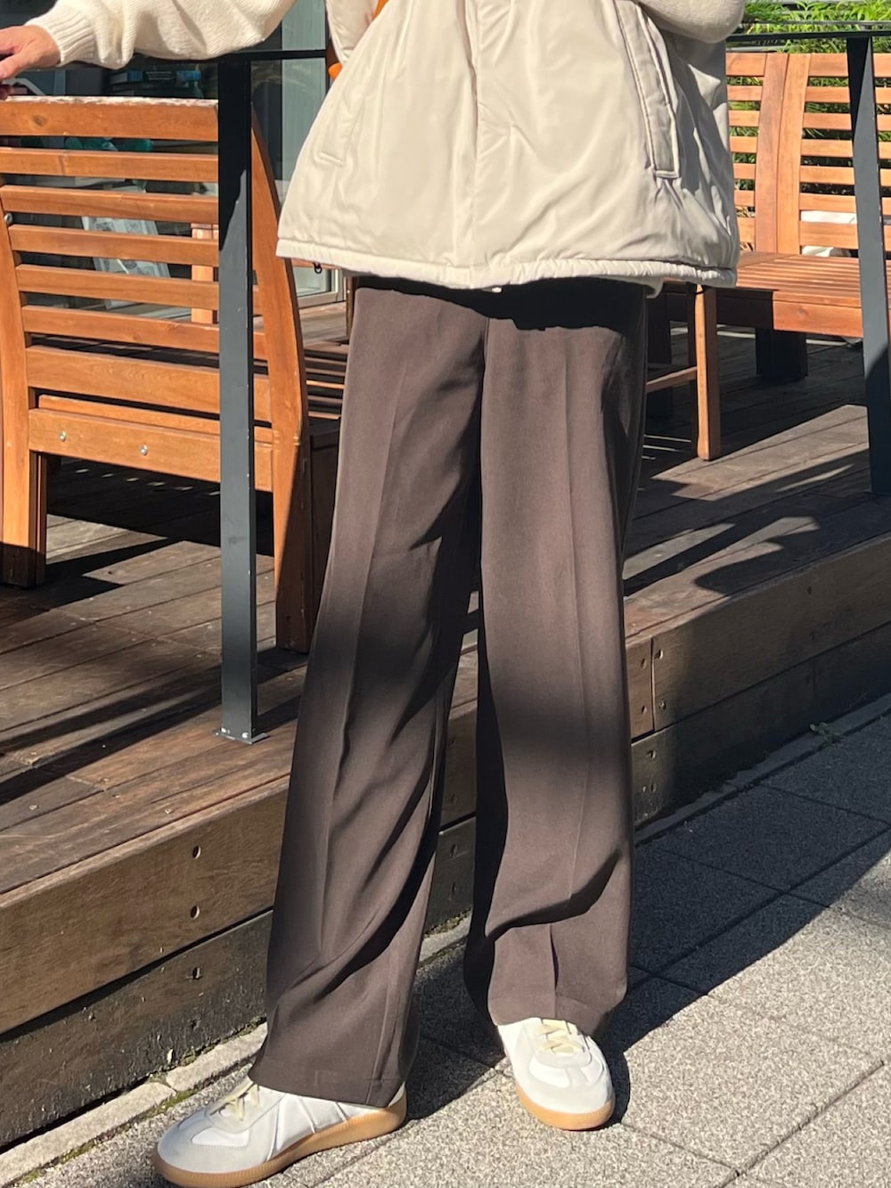 ブラウン系のボストンバッグ、ホワイト系のニット/セーター、ブラウン系のスラックスを着用したメンズの秋コーディネートの5枚目の写真