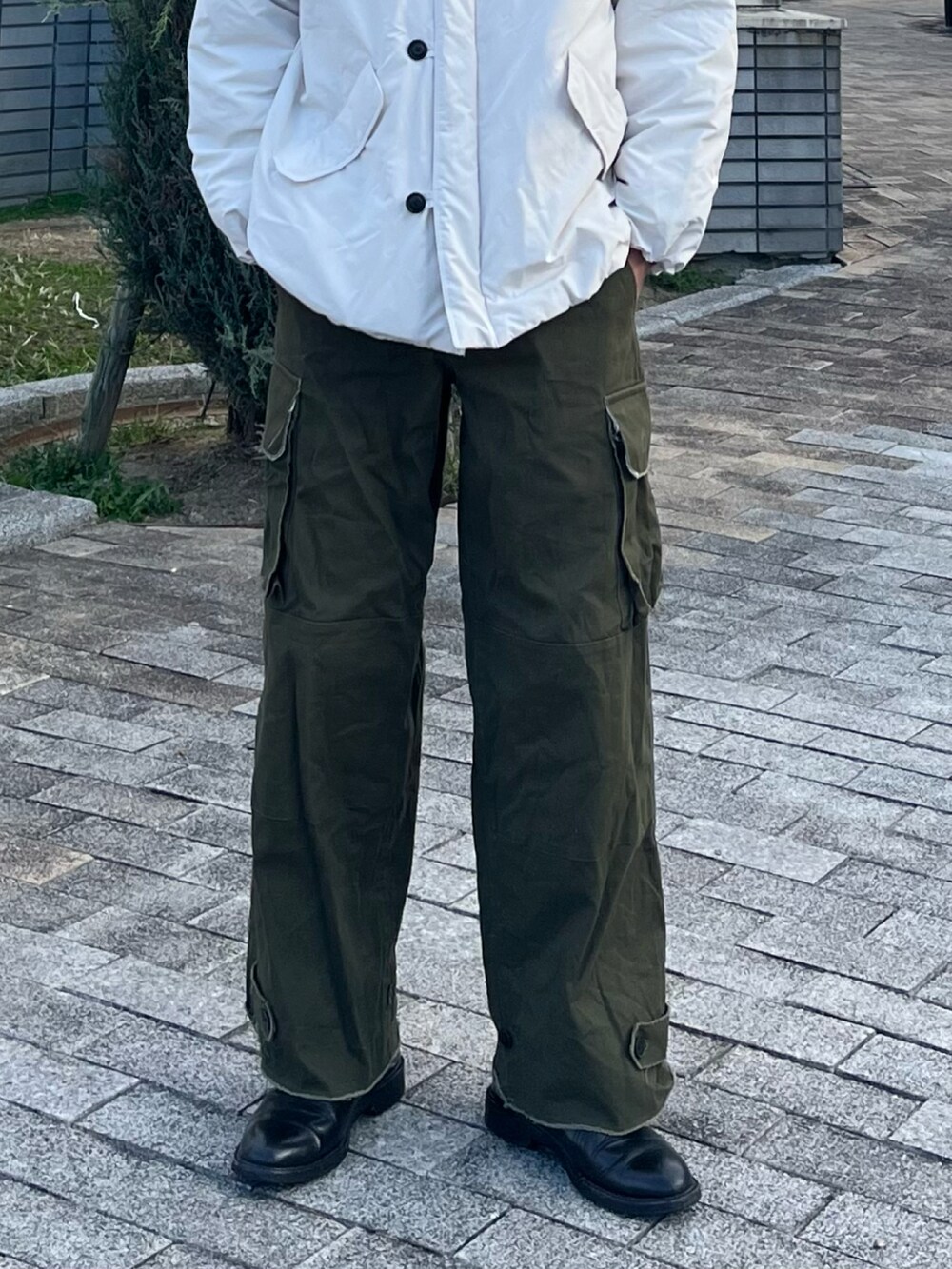 ホワイト系のダウンジャケット/コート、グリーン系のカーゴパンツ、ブラック系のブーツを着用したメンズの冬コーディネートの5枚目の写真