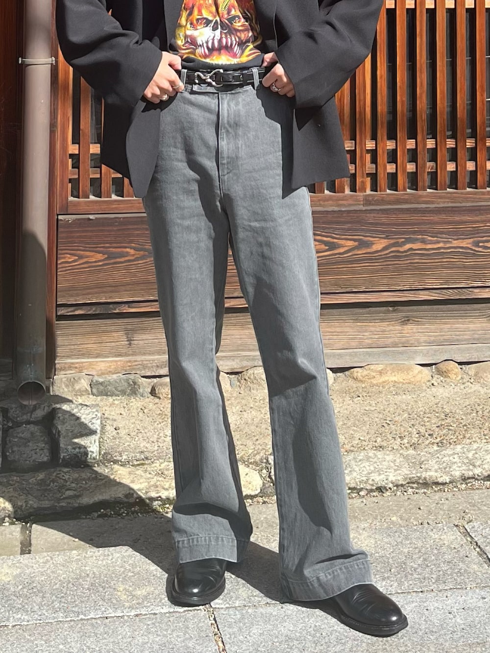 グレー系のデニムパンツ、ブラック系のテーラードジャケット、ブラック系のブーツを着用したメンズの春コーディネートの4枚目の写真