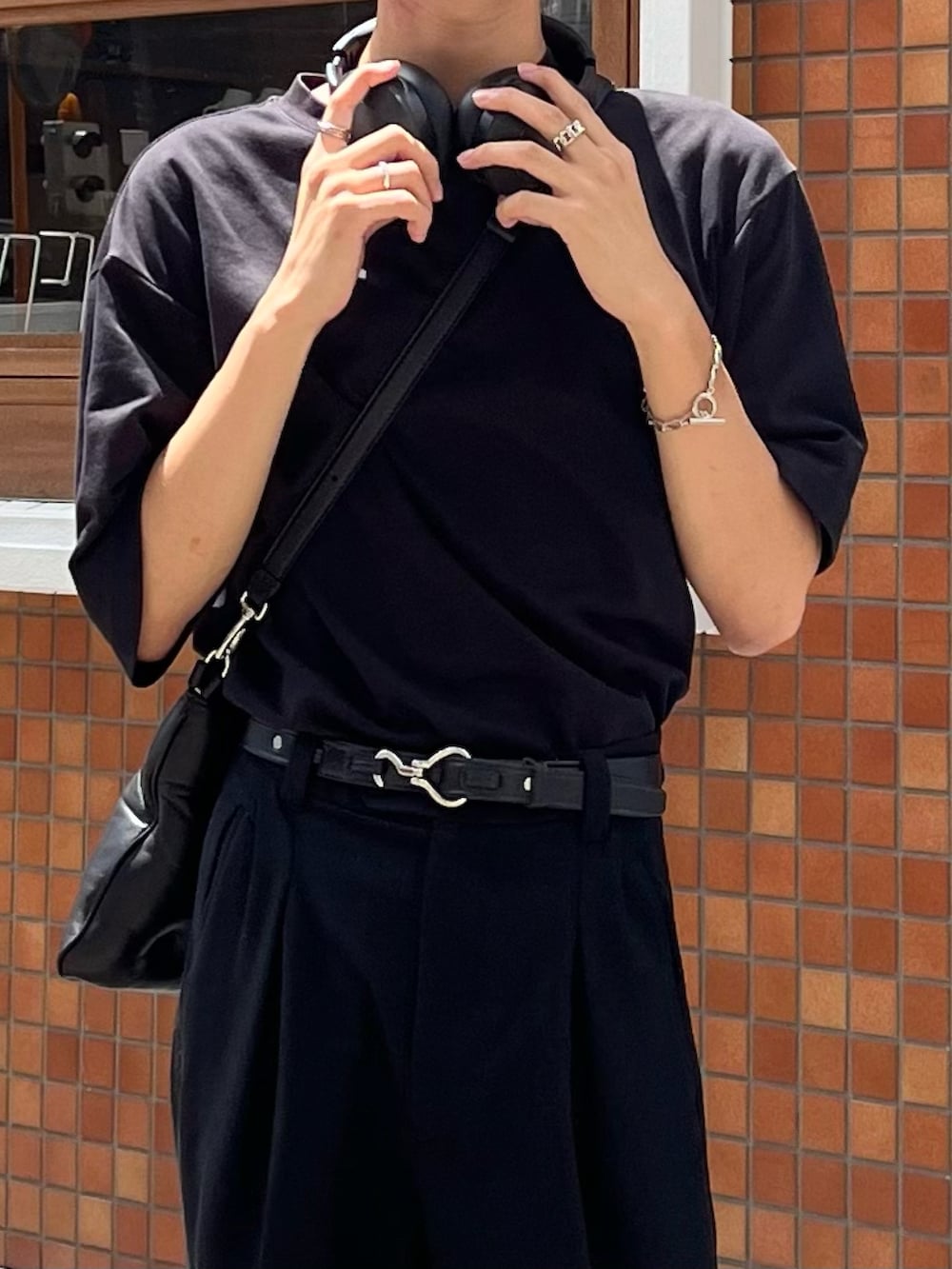 ブラック系のTシャツ/カットソー、ブラック系のスラックス、ブラック系のブーツを着用したメンズの夏コーディネートの4枚目の写真