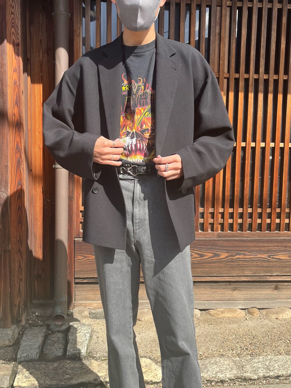 グレー系のデニムパンツ、ブラック系のテーラードジャケット、ブラック系のブーツを着用したメンズの春コーディネートの3枚目の写真