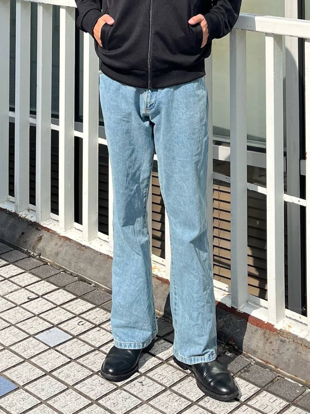 ブラック系のジャージ、ブラック系のハンドバッグ、ブルー系のデニムパンツを着用したメンズの秋コーディネートの5枚目の写真