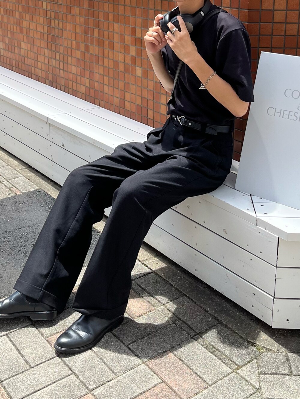 ブラック系のTシャツ/カットソー、ブラック系のスラックス、ブラック系のブーツを着用したメンズの夏コーディネートの3枚目の写真