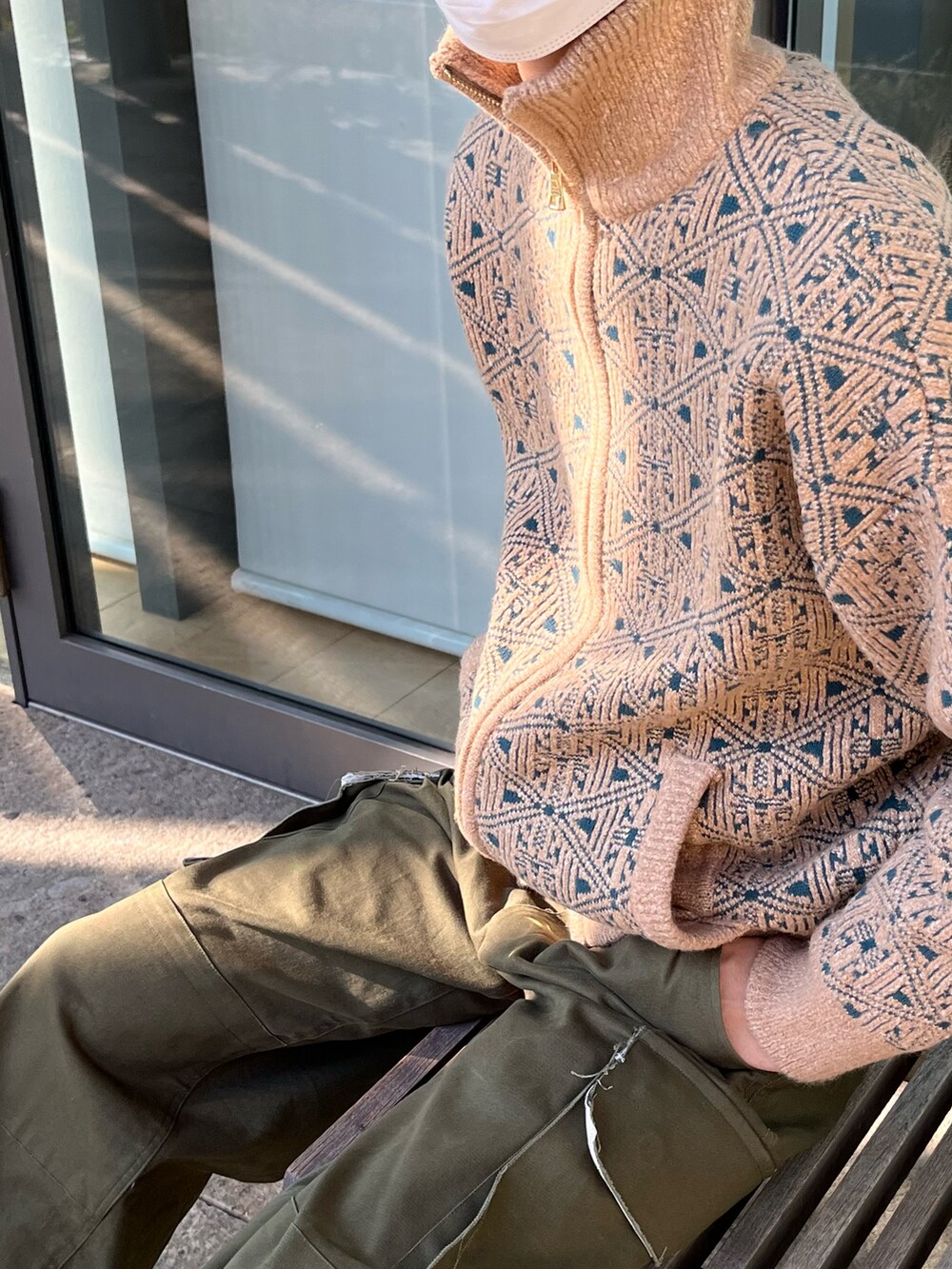 グリーン系のカーゴパンツ、ブラック系のブーツ、ベージュ系のニット/セーターを着用したメンズの冬コーディネートの4枚目の写真