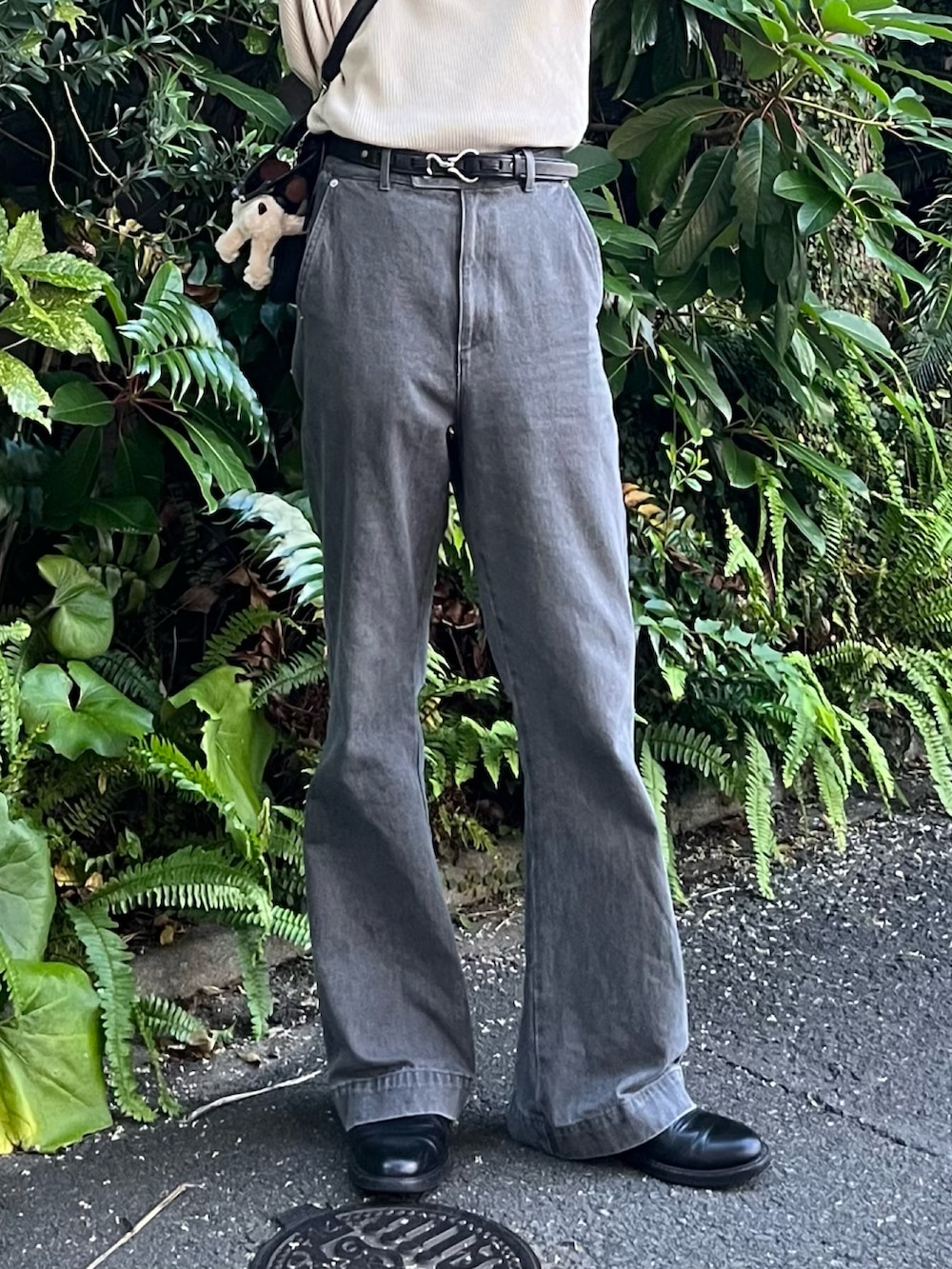 グレー系のデニムパンツ、ブラック系のブーツ、ベージュ系のポロシャツを着用したメンズの夏コーディネートの5枚目の写真