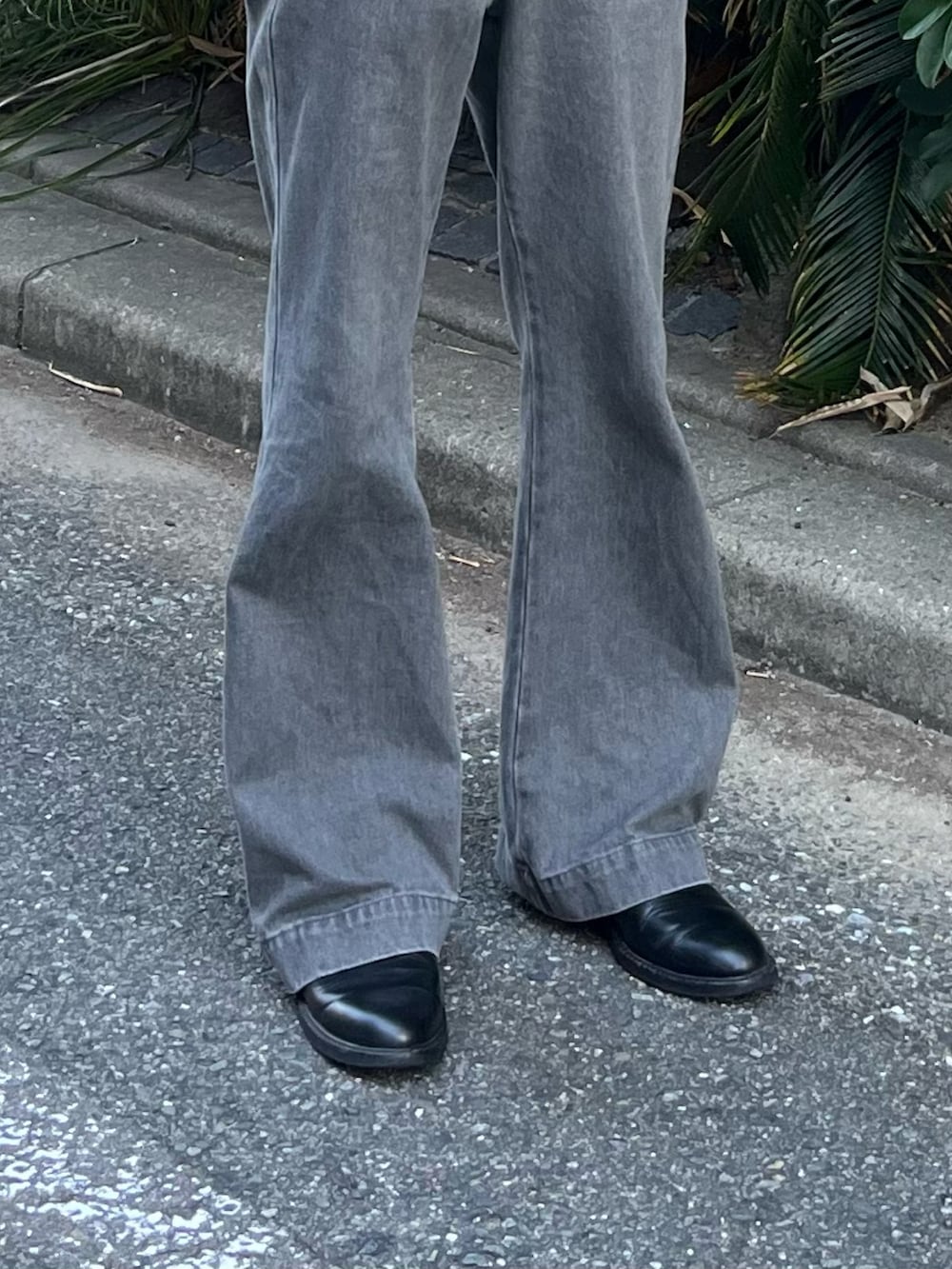 グレー系のデニムパンツ、ブラック系のブーツ、ベージュ系のポロシャツを着用したメンズの夏コーディネートの4枚目の写真