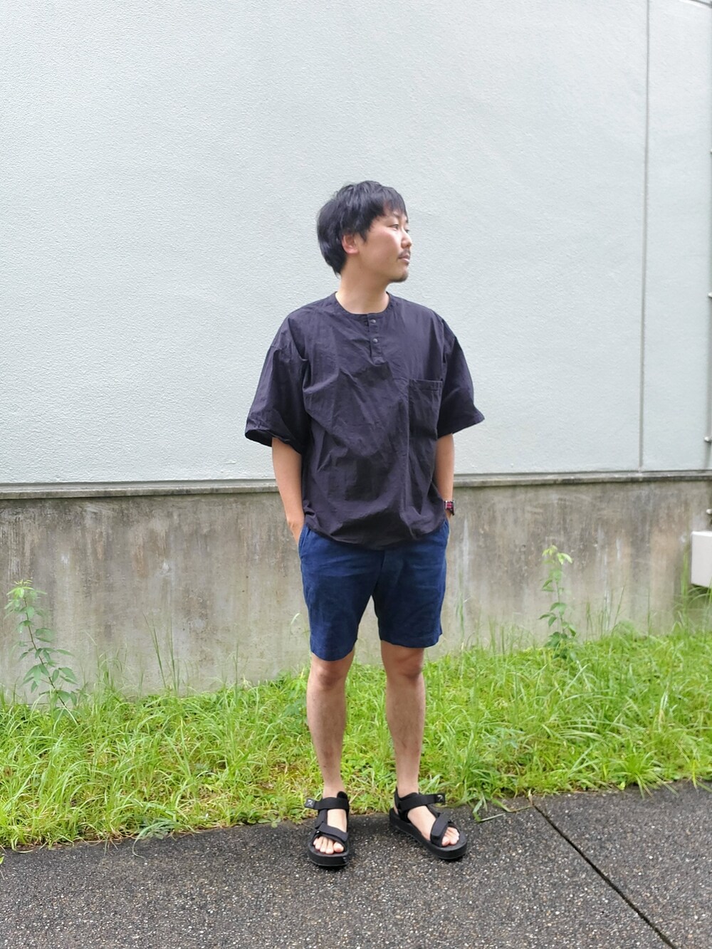 ブラック系のトップス、ブルー系のパンツ、ブラック系のサンダルを着用したメンズの夏コーディネートの2枚目の写真