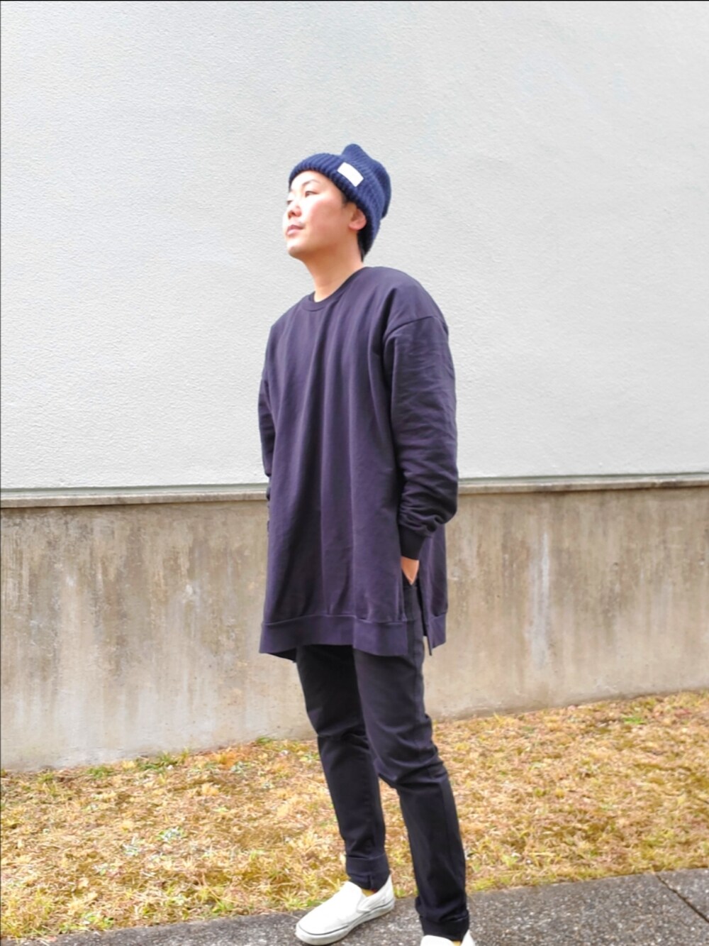 ブラック系のダウンジャケット/コート、ブラック系のパンツ、ホワイト系のスリッポンを着用したメンズの冬コーディネートの2枚目の写真