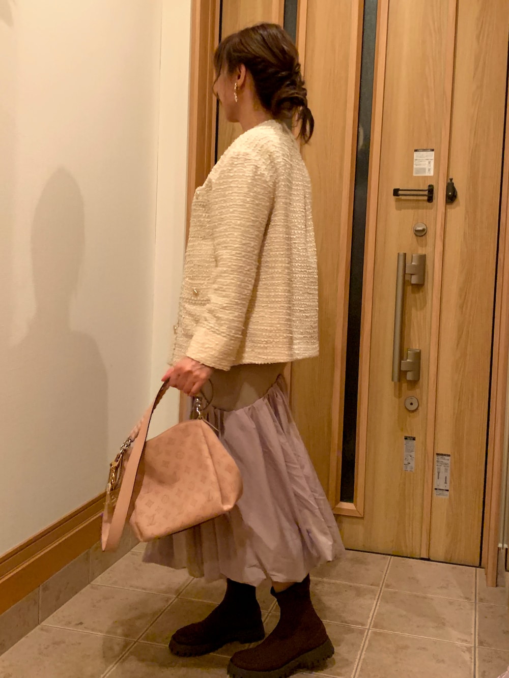 ホワイト系のノーカラージャケット、ベージュ系のワンピース、ブラウン系のブーツを着用したレディースの秋コーディネートの3枚目の写真