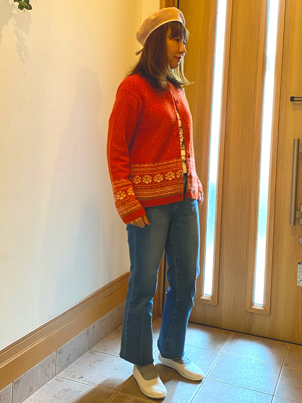 オレンジ系のカーディガン/ボレロ、ブルー系のデニムパンツ、ホワイト系のスリッポンを着用したレディースの秋コーディネートの3枚目の写真