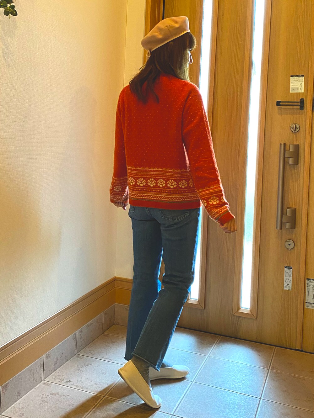 オレンジ系のカーディガン/ボレロ、ブルー系のデニムパンツ、ホワイト系のスリッポンを着用したレディースの秋コーディネートの2枚目の写真