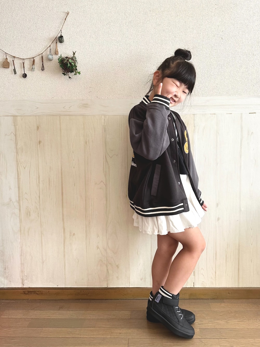 ブラック系のTシャツ/カットソー、ブラック系のジャケット/アウター、ホワイト系のスカートを着用したキッズの秋コーディネートの3枚目の写真