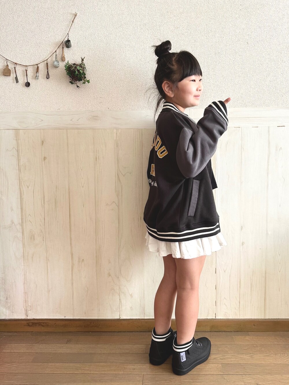 ブラック系のTシャツ/カットソー、ブラック系のジャケット/アウター、ホワイト系のスカートを着用したキッズの秋コーディネートの2枚目の写真