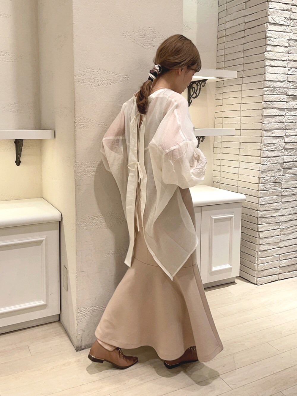 ベージュ系のスカート、ブラウン系のドレスシューズ、ベージュ系のシャツ/ブラウスを着用したレディースの春コーディネートの2枚目の写真