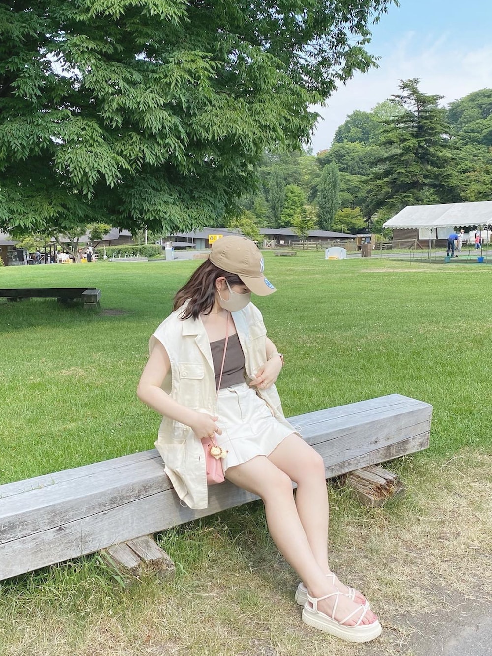 ホワイト系のミリタリージャケット、ホワイト系のデニムスカート、ブラウン系のキャミソールを着用したレディースの夏コーディネートの4枚目の写真