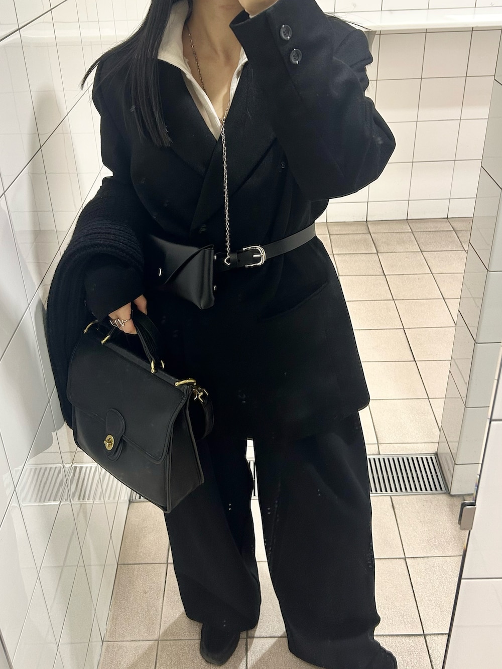 ブラック系のその他パンツ、ベージュ系のTシャツ/カットソー、ブラック系のベルトを着用したレディースの冬コーディネートの2枚目の写真