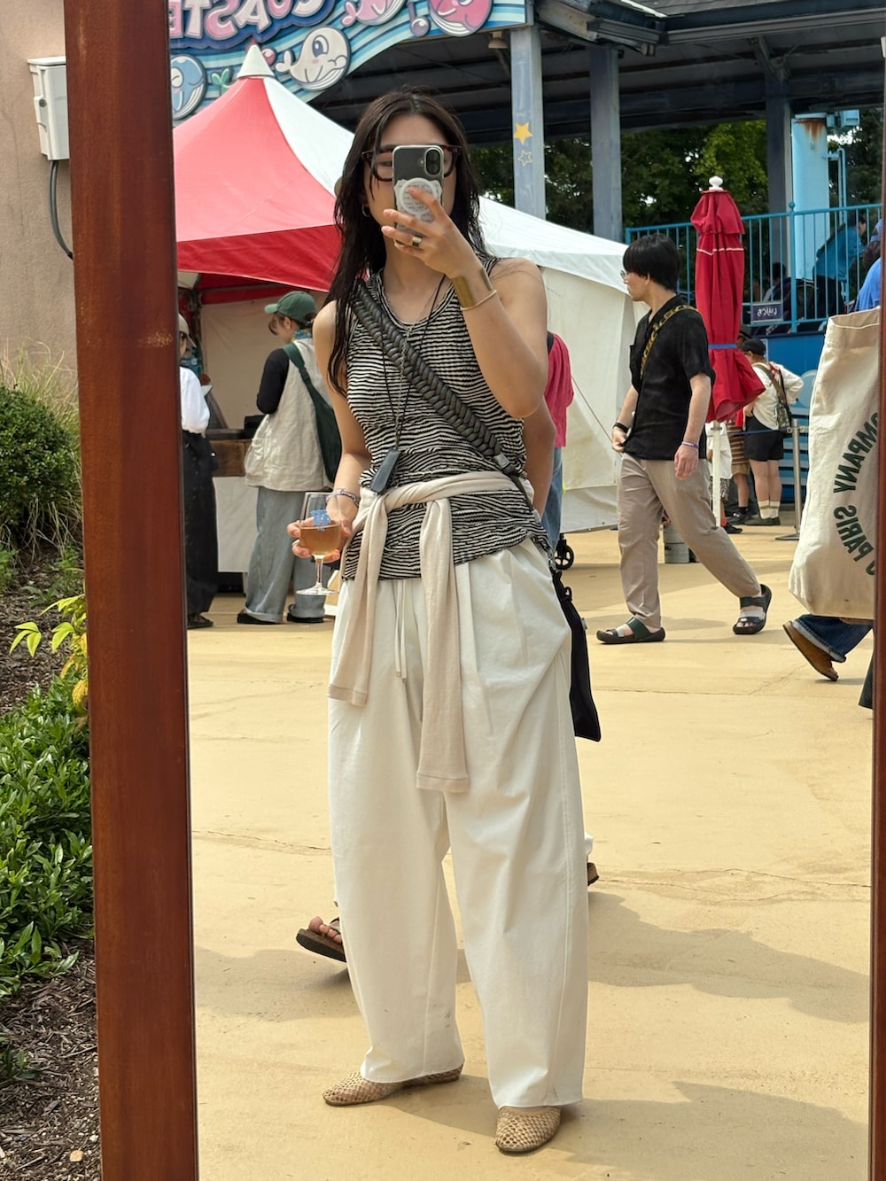 ベージュ系のシューズ、ホワイト系のパンツ、シルバー系のショルダーバッグを着用したレディースの夏コーディネートの3枚目の写真